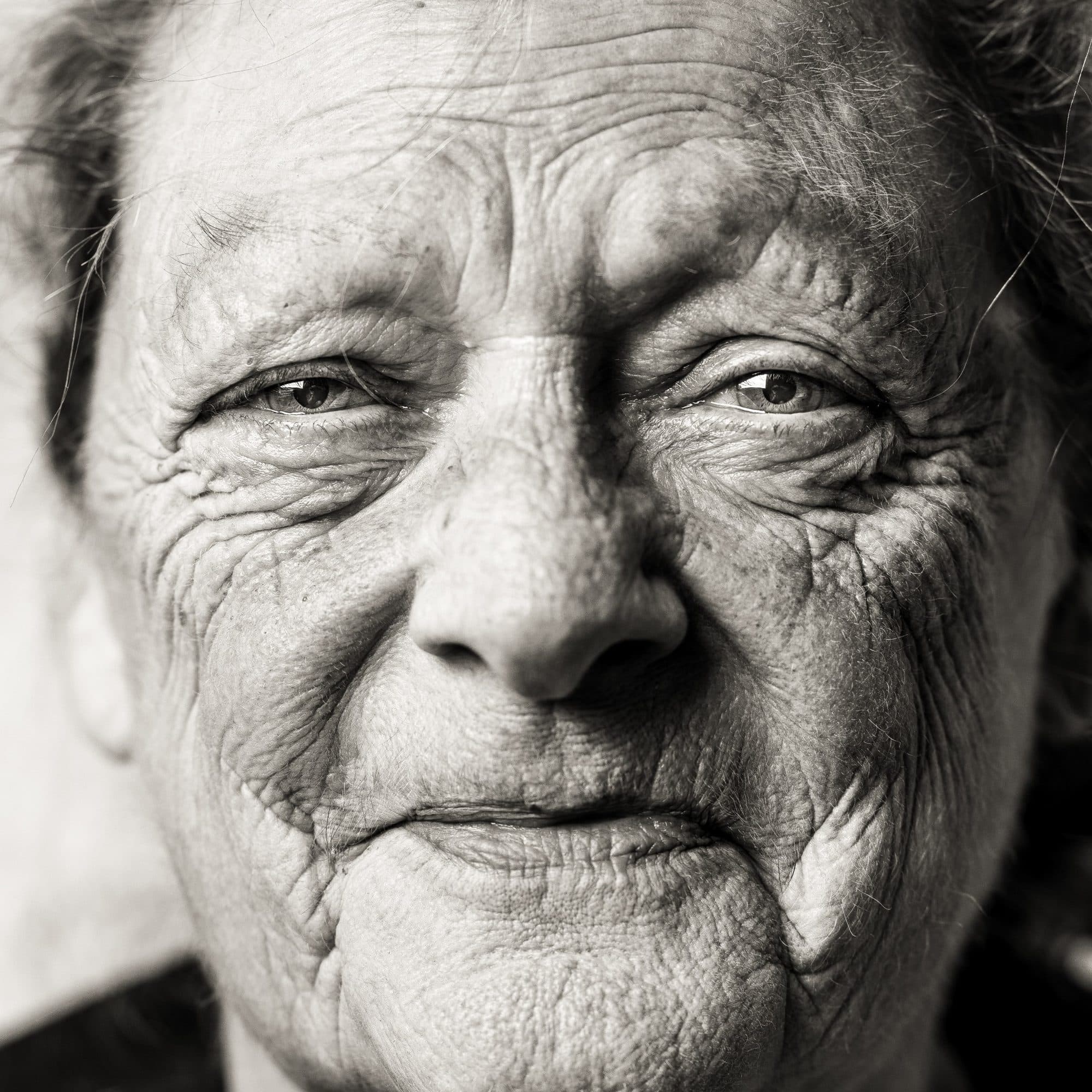 A close, dignified black-and-white portrait of an elderly woman
