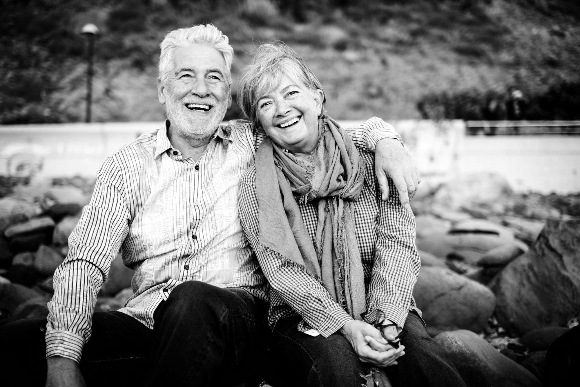 A senior couple laughing together, arm in arm